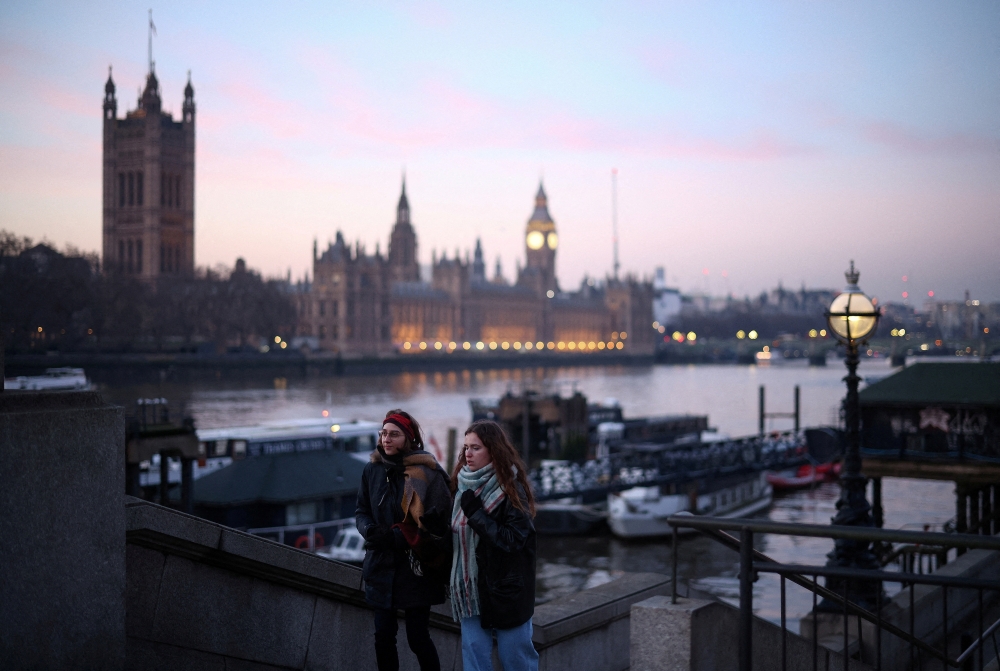  People walk along the South Bank with the Houses of Parliament in the distance, in London, Britain, January 17, 2023. REUTERS/Henry Nicholls/File Photo
