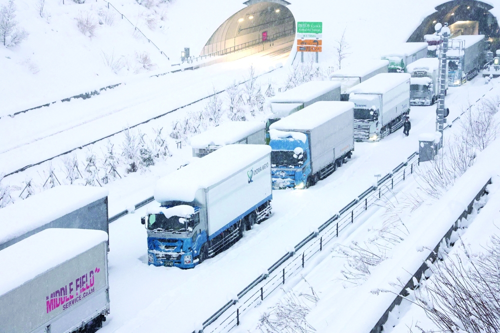 Trucks are seen stuck due to heavy snow on the Shin-Meishin Expressway in Yokkaichi, Mie Prefecture, on Wednesday. - AFP