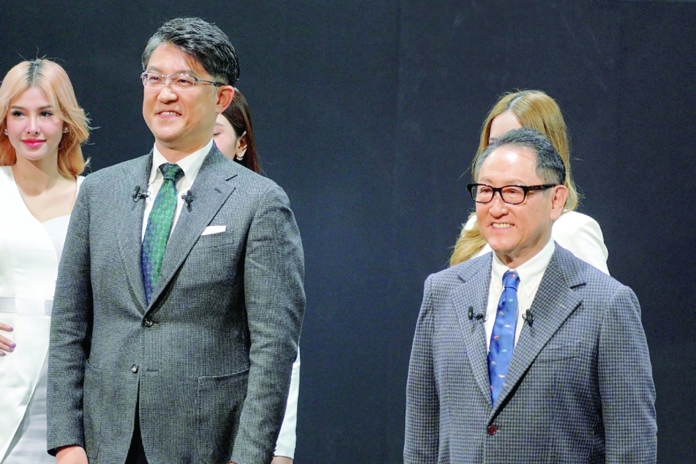 Toyota Motor chief Akio Toyoda (R) and executive officer Koji Sato (front L) posing during the Tokyo Auto Salon, a festival for modified cars, at Makuhari Messe in Chiba City, suburban Tokyo. - AFP
