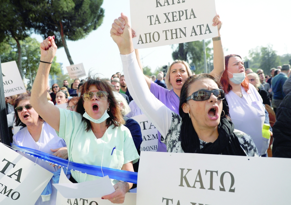 Workers shout slogans during a protest demanding for inflation-linked salary increases outside the Ministry of Finance in Nicosia. - Reuters