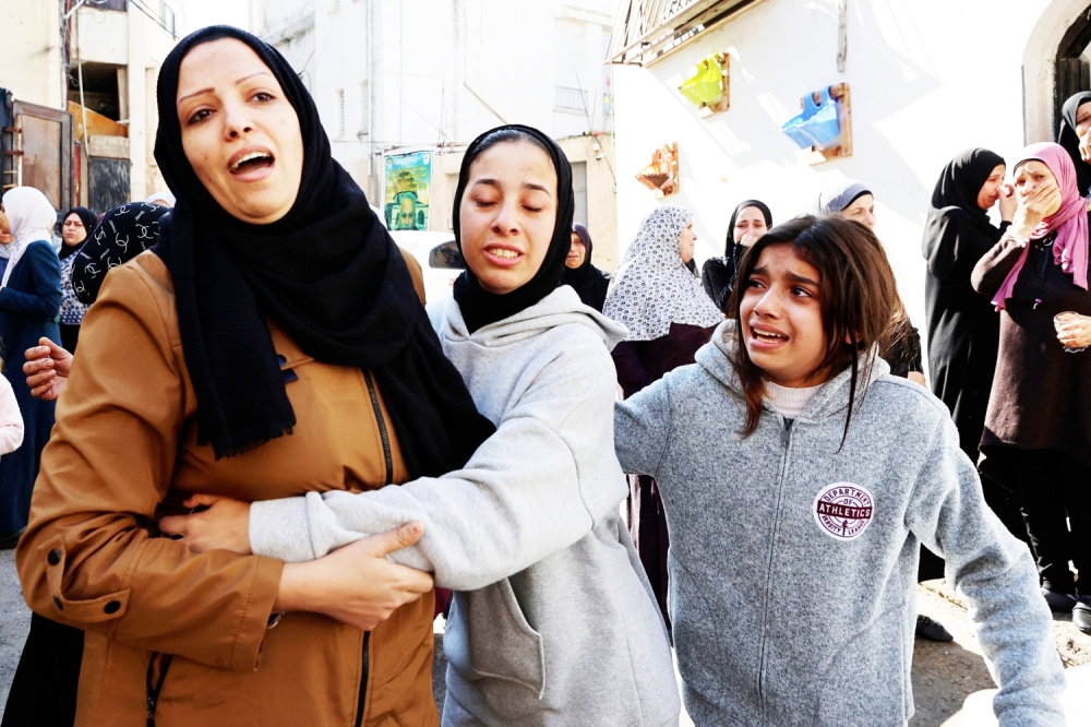 Relatives mourn during the funeral of Palestinians killed during an Israeli raid on the Jenin refugee camp. — AFP