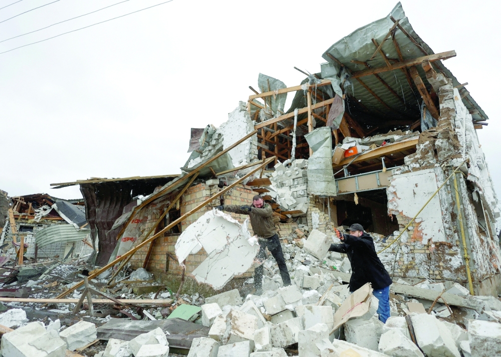 Local residents remove debris from a house of their  neighbour damaged by a Russian military strike, amid Russia's attack on Ukraine, in the town of Hlevakha, outside Kyiv, Ukraine. - Reuters
