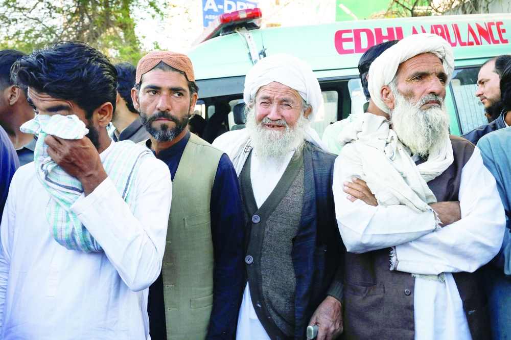Men mourn the death of their relatives, who were killed after a bus crash in Lasbela District of Balochistan province, outside a hospital morgue in Karachi, Pakistan, on Sunday. - Reuters