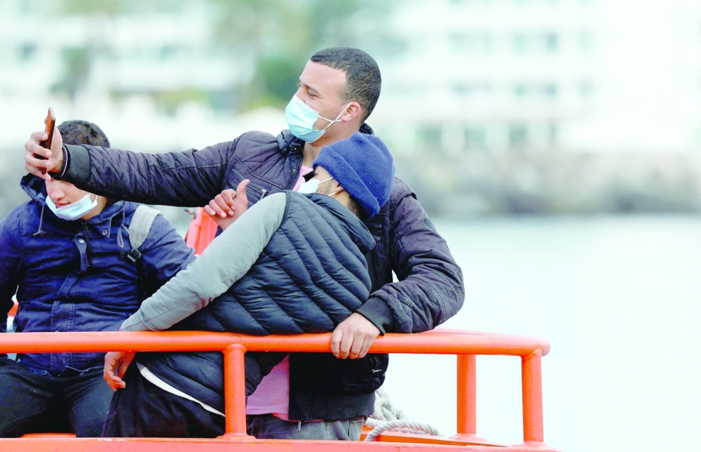 Migrants wait to disembark from a Spanish coast guard vessel, in the port of Arguineguin, in the island of Gran Canaria, Spain. -- Reuters