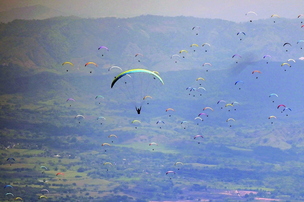 Pilots compete during the seventh stage of the Paragliding Americas Cup, in Roldanillo, Valle del Cauca department, Colombia, on Monday. Pilots from 38 countries are competing to earn the needed points to get a spot in the upcoming Paragliding World Cup. -- AFP