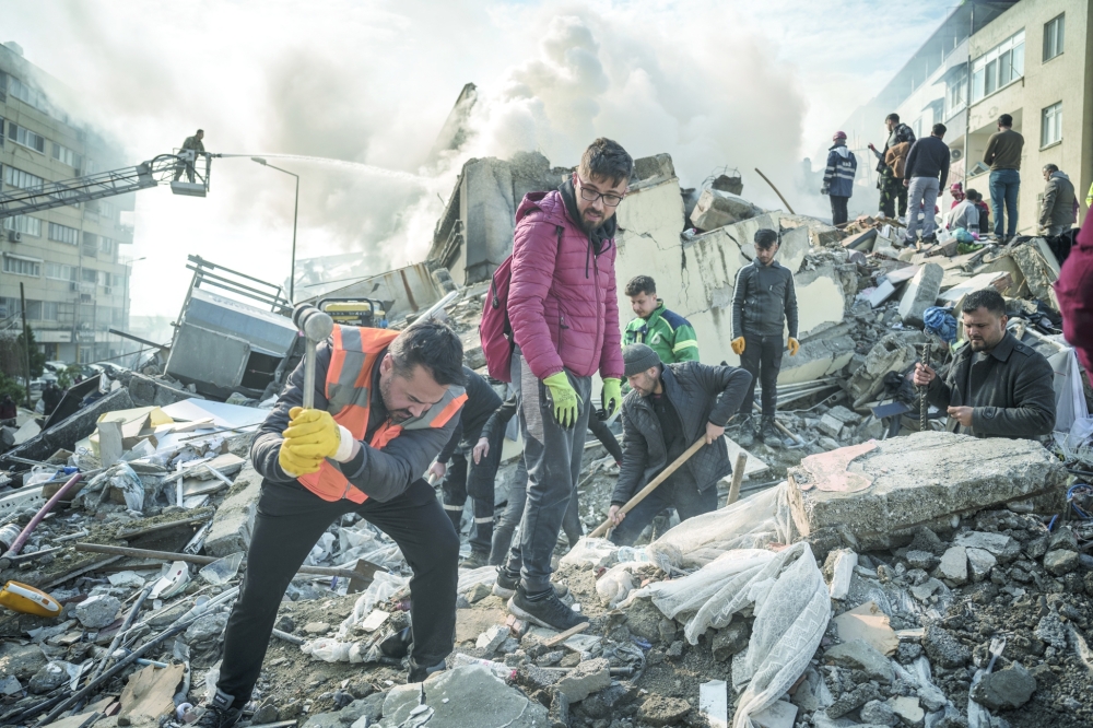 Rescue workers comb through the wreckage of a collapsed building in Iskenderun, Turkey.