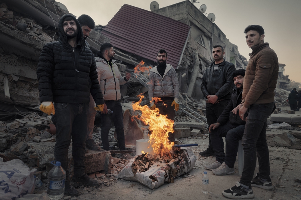 Men keep warm by a bonfire in the old quarter of Antakya, in Hatay Province,Turkey, three days after the earthquake, on Thursday, Feb. 9, 2023. (Emily Garthwaite/The New York Times)
