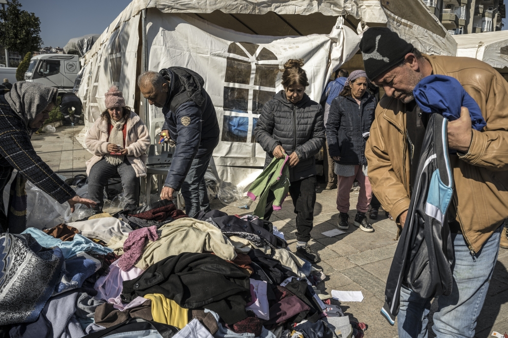 Earthquake survivors pick from donated clothes in Antakya, in Hatay Province, Turkey, on Thursday, Feb. 9, 2023. (Sergey Ponomarev/The New York Times)