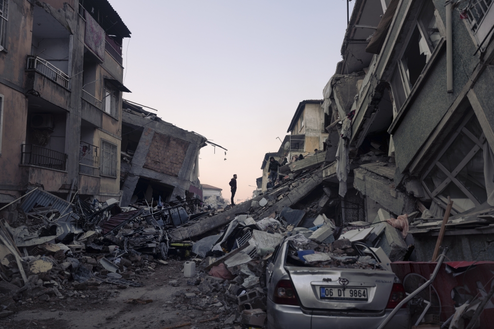 A man watches volunteers search for bodies in the old quarter of Antakya, Hatay region, Turkey, three days after the earthquake, on Thursday, Feb. 9, 2023. (Emily Garthwaite/The New York Times)
