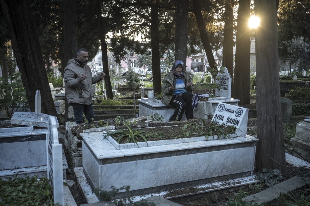 A family prays at the tomb where they just buried three of their family members in Antakya, Hatay region, Turkey, on Feb. 9, 2023. (Sergey Ponomarev/The New York Times)