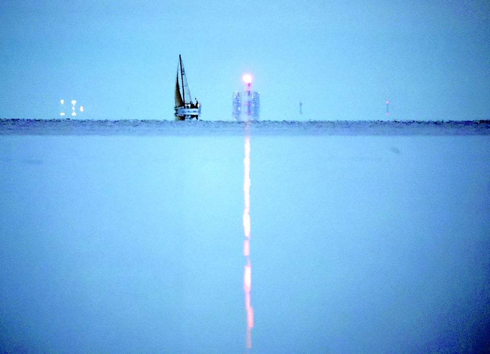 A yacht sails past a gas flare at Portovaya Bay on the coast of the Gulf of Finland in the Leningrad Region, Russia. -- Reuters