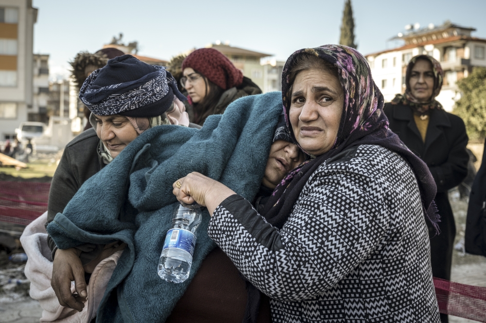 Distraught women watch efforts to find survivors in Antakya, Turkey, Feb. 8, 2023. (Sergey Ponomarev/The New York Times)