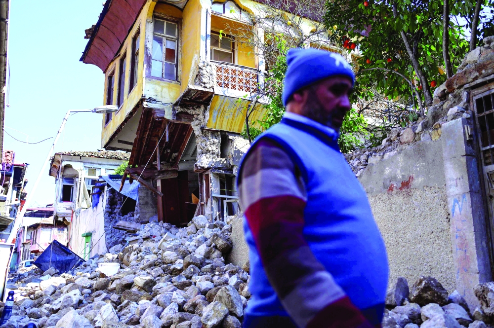 A man walks by the rubble of collapsed buildings in the historic southern city of Antakya. - AFP

