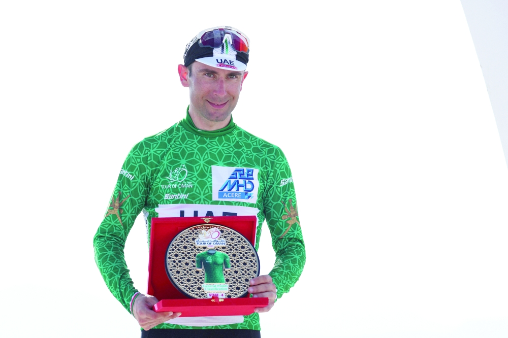 Italian Diego Ulissi of UAE Team Emirates poses in the green jersey on the podium after winning the fourth stage of the 2023 Tour of Oman, from Izki to Yitti Hills, on February 14, 2023. (Photo by Thomas SAMSON / AFP)