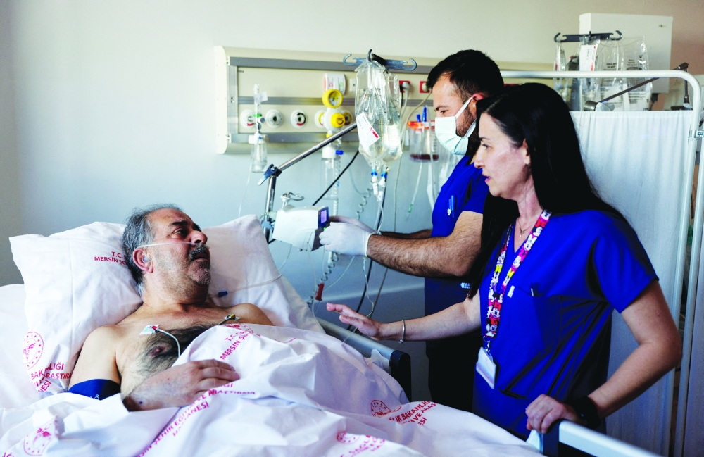 Huseyin Berber, 62, a survivor who was rescued after being trapped under the rubble for 187 hours in Antakya, speaks to media and doctors as he receives medical attention at Mersin City hospital. -- Reuters