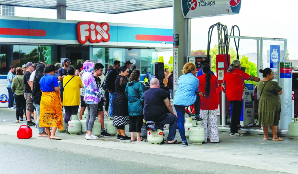 People wait in a queue to fill their gas bottles in the aftermath of Cyclone Gabrielle near Napier on Thursday. -- AFP
