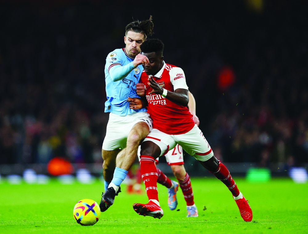 Soccer Football - Premier League - Arsenal v Manchester City - Emirates Stadium, London, Britain - February 15, 2023 Arsenal's Bukayo Saka in action with Manchester City's Jack Grealish Action Images via Reuters/Matthew Childs EDITORIAL USE ONLY. No use with unauthorized audio, video, data, fixture lists, club/league logos or 'live' services. Online in-match use limited to 75 images, no video emulation. No use in betting, games or single club /league/player publications.  Please contact your account representative for further details.