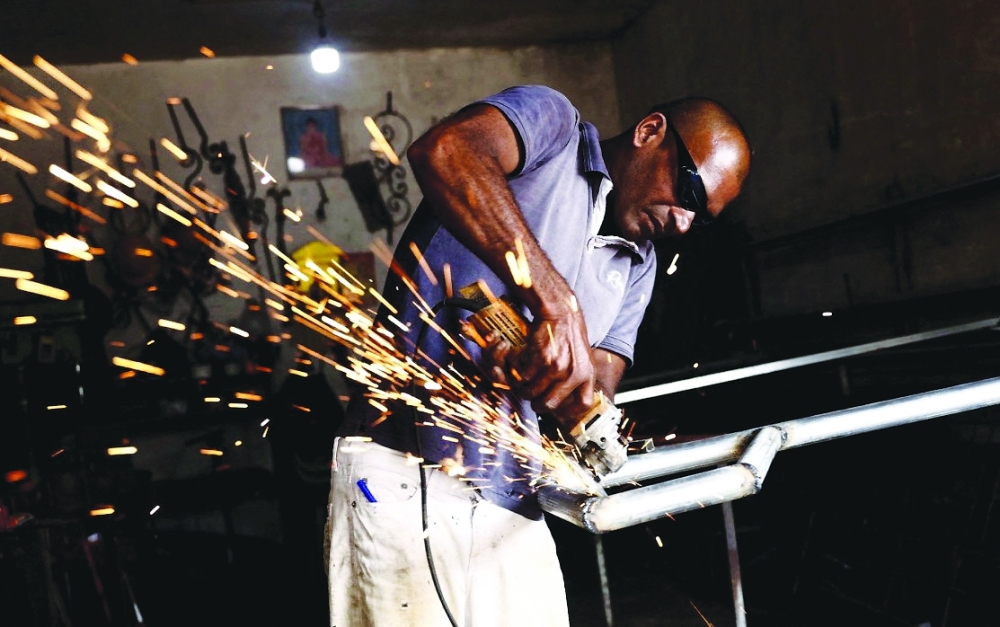 A man works at a welding shop in Colombo. An unprecedented financial crisis last year saw Sri Lanka's 22 million people suffer through months of food and fuel shortages, along with lengthy power cuts. -- Reuters
