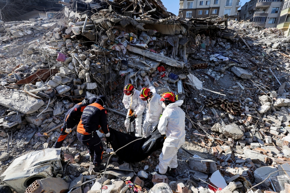 Rescuers carry the body of a victim taken out of the rubble, in the aftermath of the deadly earthquake, in Antakya, on Friday. — Reuters