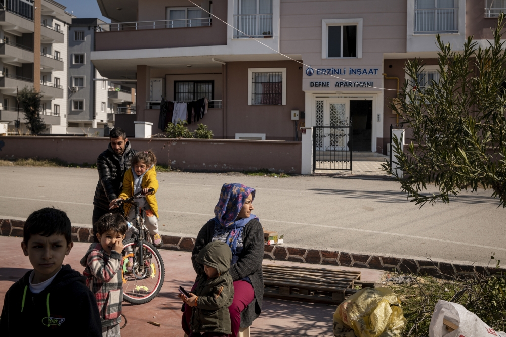 Residents outside a tent providing aid and shelter to some who cannot return to their homes due to structural damage in Erzin, Turkey, Feb. 14, 2023. (Nicole Tung/The New York Times)