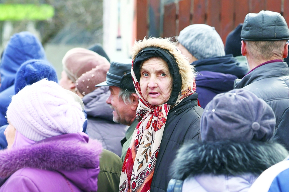 People queue for meals from World Central Kitchen food truck on a street in Kherson, Ukraine, on Wednesday. - Reuters