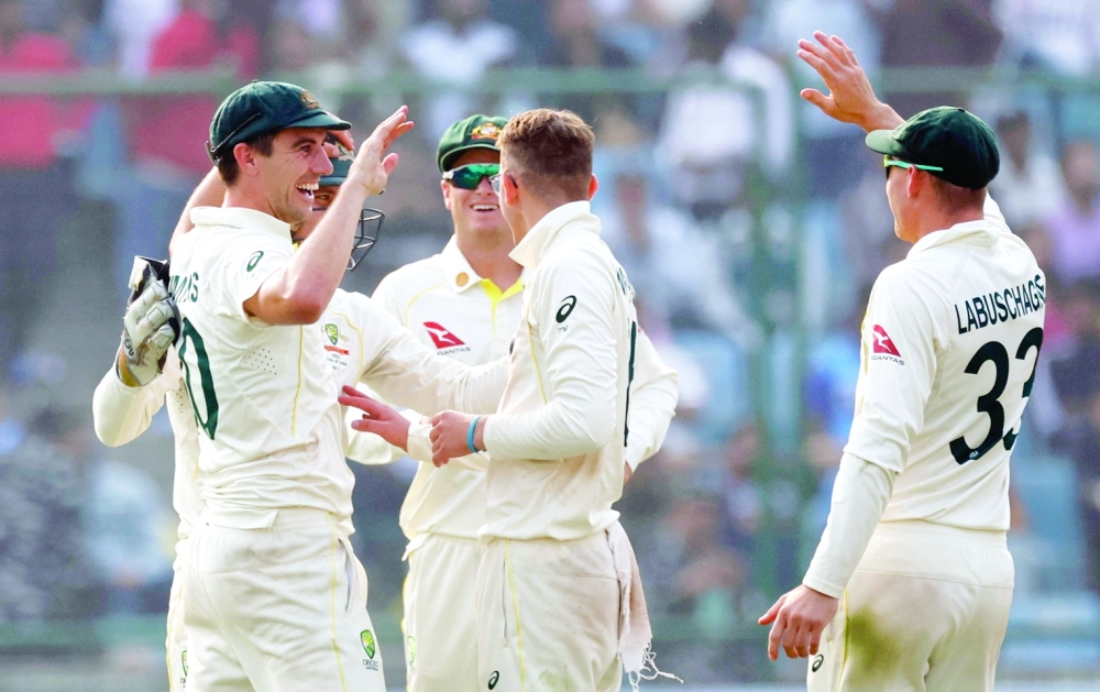 Australia's Pat Cummins celebrates with teammates after taking the wicket of India's Ravichandran Ashwin during the second Test. -- Reuters