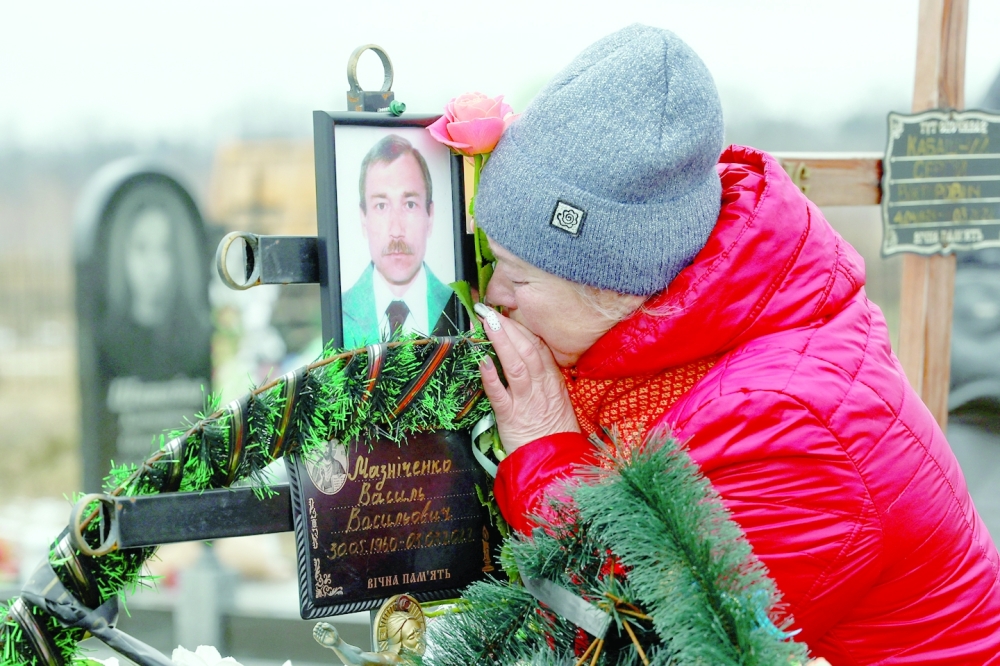 Wife Natalia reacts at the grave of Vasyl Maznichenko, local resident killed by Russian soldiers during occupation the Bucha town, outside Kyiv. - Reuters
