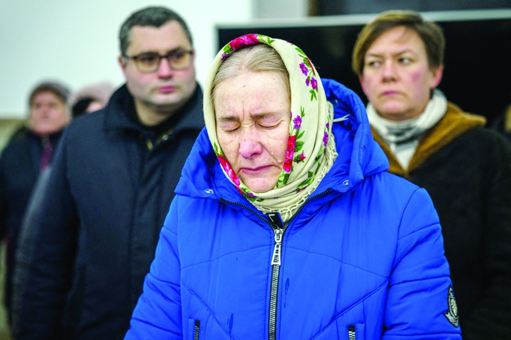 A woman reacts during a prayer service in St Andrew's Church in Bucha, near Kyiv on the first anniversary of the Russian invasion of Ukraine. - AFP
