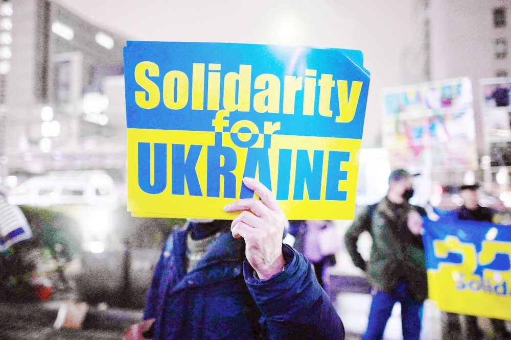 People take part in a candlelight vigil outside UN University in Tokyo to mark the one year anniversary of the Russian invasion of Ukraine. -- AFP

