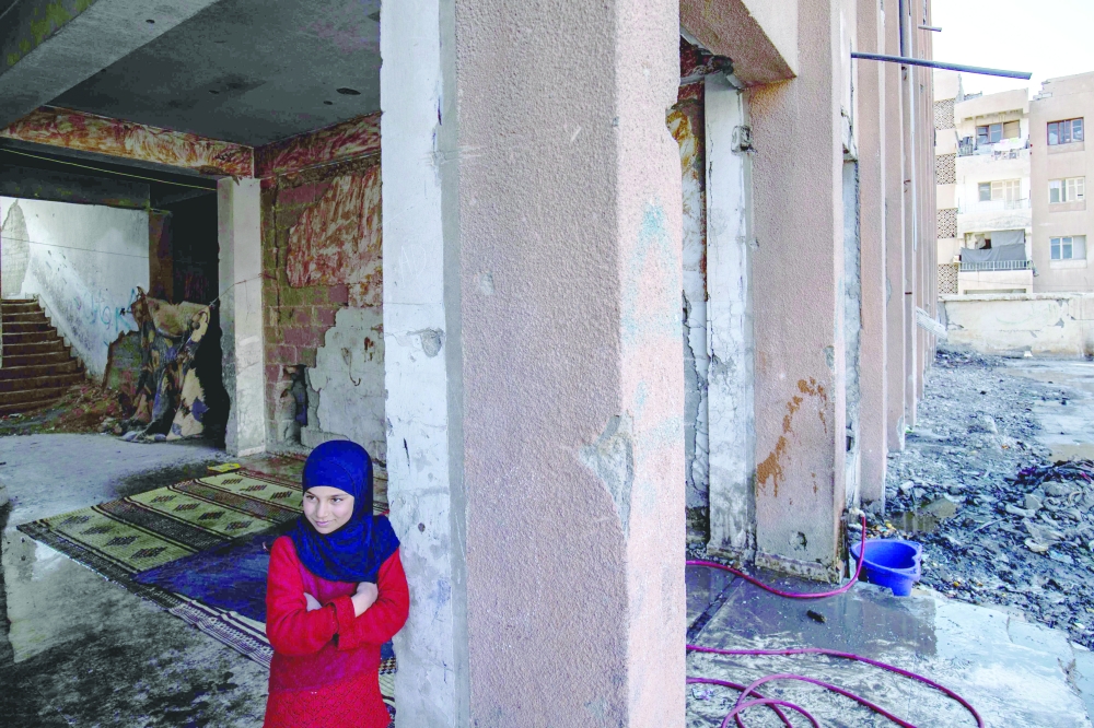 A displaced Syrian child living in war-damaged buildings amid fears that the already fragile dwellings will not withstand an earthquake in Raqa. — AFP

