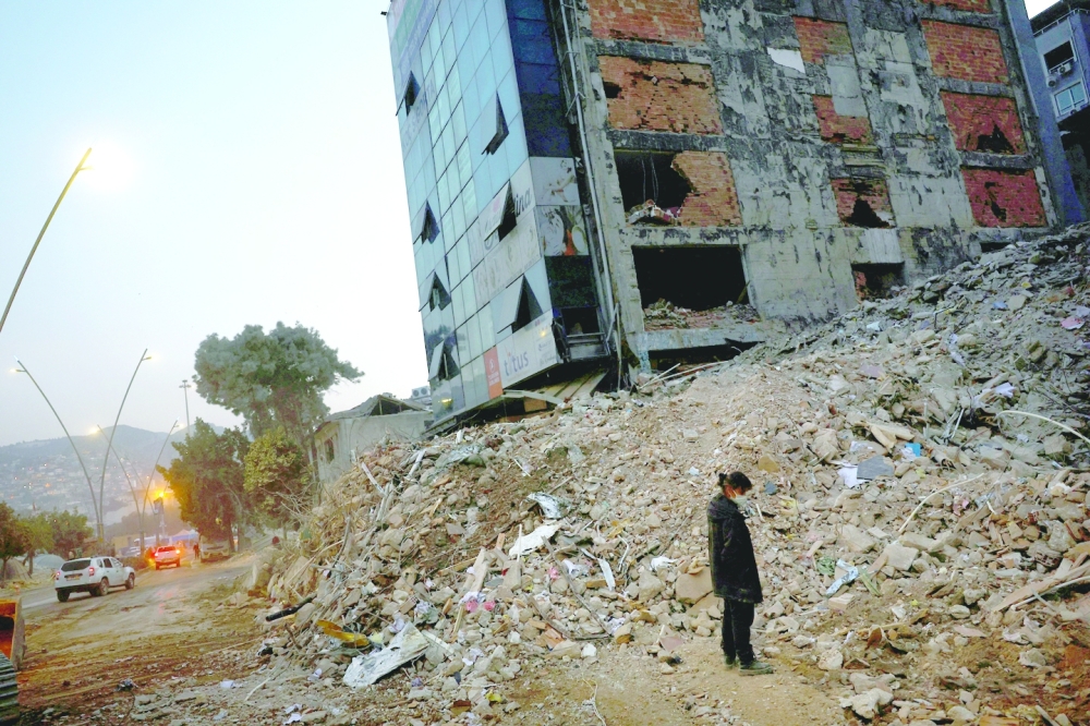 A woman looks through the remains of her collapsed home in Antakya,Turkiye. — Reuters