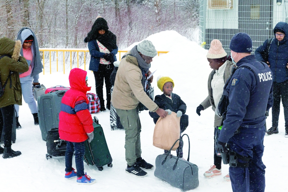 An Angolan family explaining to their young daughter that she can eat once she's let inside the processing facility at the Roxham Road border crossing in Saint-Bernard-de-Lacolle, Quebec, Canada. 
