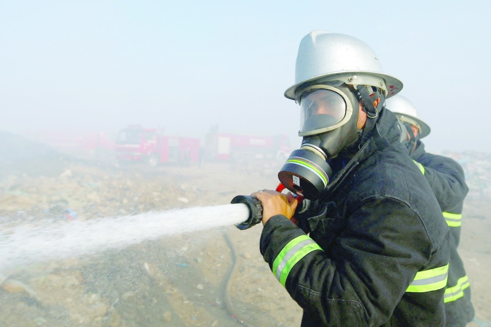 A Palestinian fireman extinguishes a fire at a garbage dumping site in Juhr al Deek, southeast of Gaza City. - Reuters