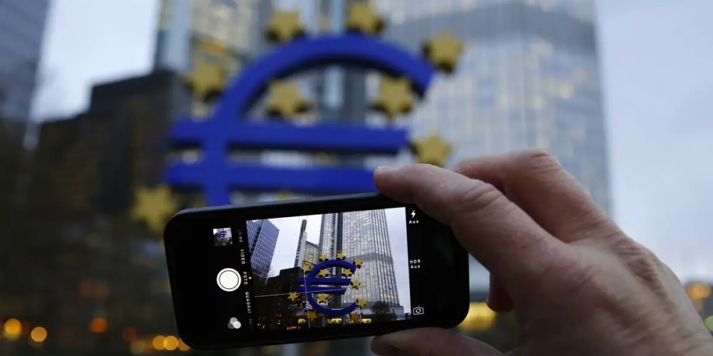 A man uses his mobile phone to take a picture of the euro sculpture outside the headquarters of the European Central Bank  in Frankfurt. — Reuters