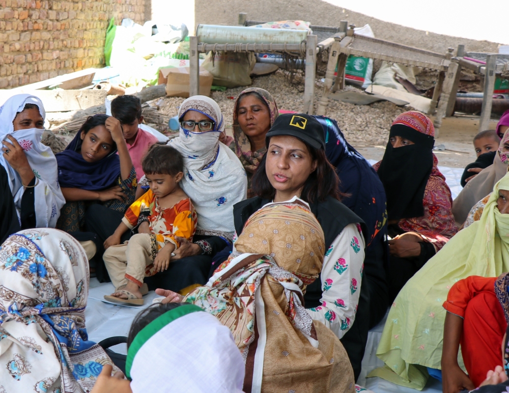 Shabnam Baloch, center, on Sept. 20, 2023 with people affected by flooding in Sindh Province in Pakistan, where she grew up. (International Rescue Committee via The New York Times)