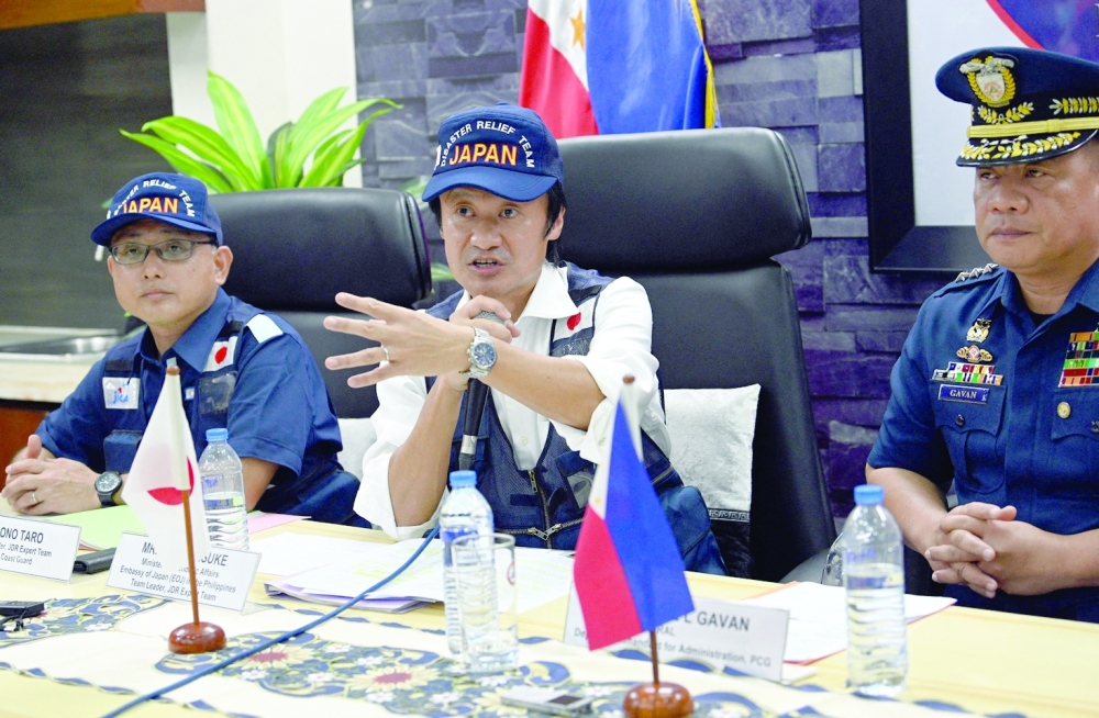 Nihei Daisuke (C), Minister of economic affairs from the Japanese embassy, speaks next to Philippine Coast Guard Vice Admiral Ronnie Gavan (C) and Ono Taro, deputy leader of the Japan Disaster Relief expert team during a press conference at the coast guard's headquarters in Manila. - AFP