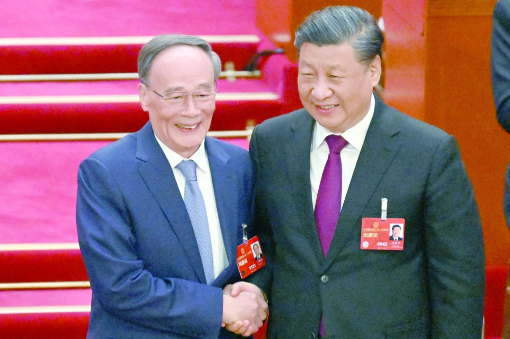 China's President Xi Jinping with former Vice President Wang Qishan during the third plenary session of the National People's Congress in Beijing. - AFP 
