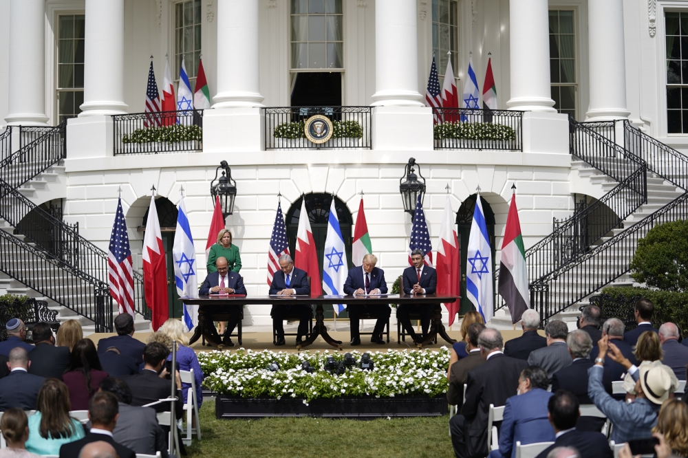 From left, Abdullatif bin Rashid Al Zayani, Minister of Foreign Affairs of Bahrain, Israeli Prime Minister Benjamin Netanyahu, U.S. President Donald Trump, and Abdullah bin Zayed bin Sultan Al Nahyan, Minister of Foreign Affairs and International Cooperation of the United Arab Emirates, sign the Abraham Accords at the White House, in Washington on Sept. 15, 2020. (Doug Mills/The New York Times)