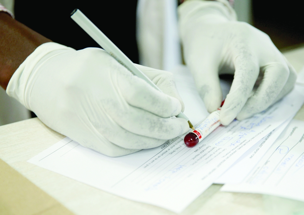 A doctor registers blood after testing a patient at a local government hospital in Harare, Zimbabwe. - Reuters