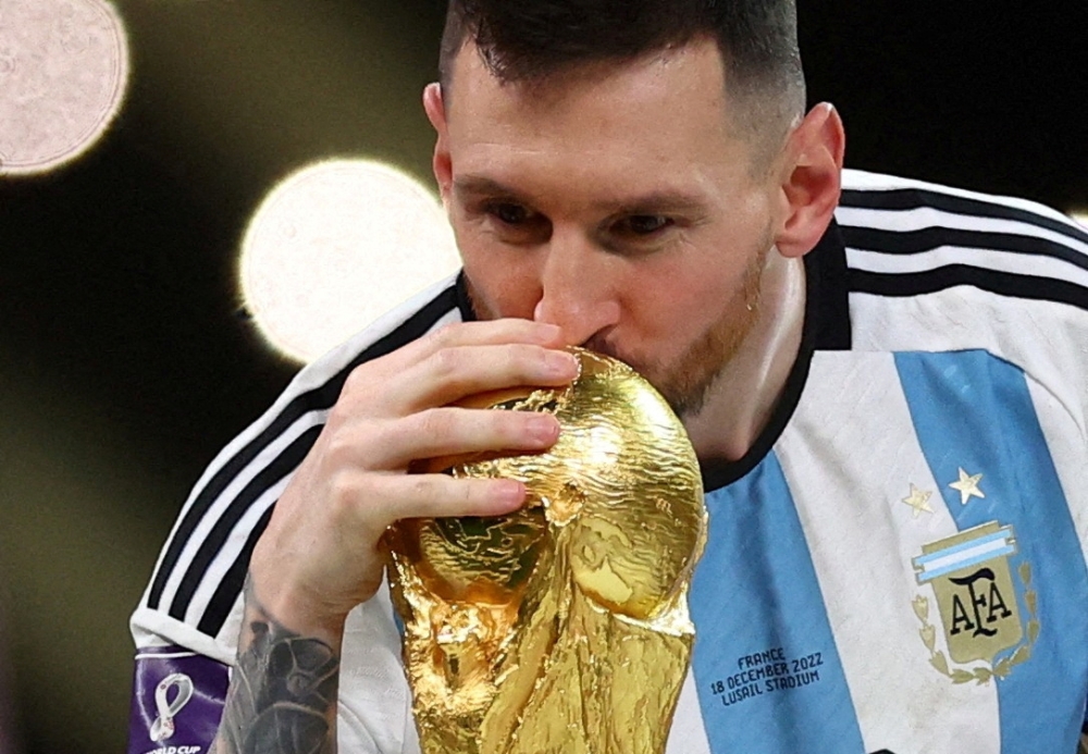 FILE PHOTO: Soccer Football - FIFA World Cup Qatar 2022 - Final - Argentina v France - Lusail Stadium, Lusail, Qatar - December 18, 2022 Argentina's Lionel Messi kisses the trophy as he celebrates winning the World Cup REUTERS/Carl Recine/File Photo
