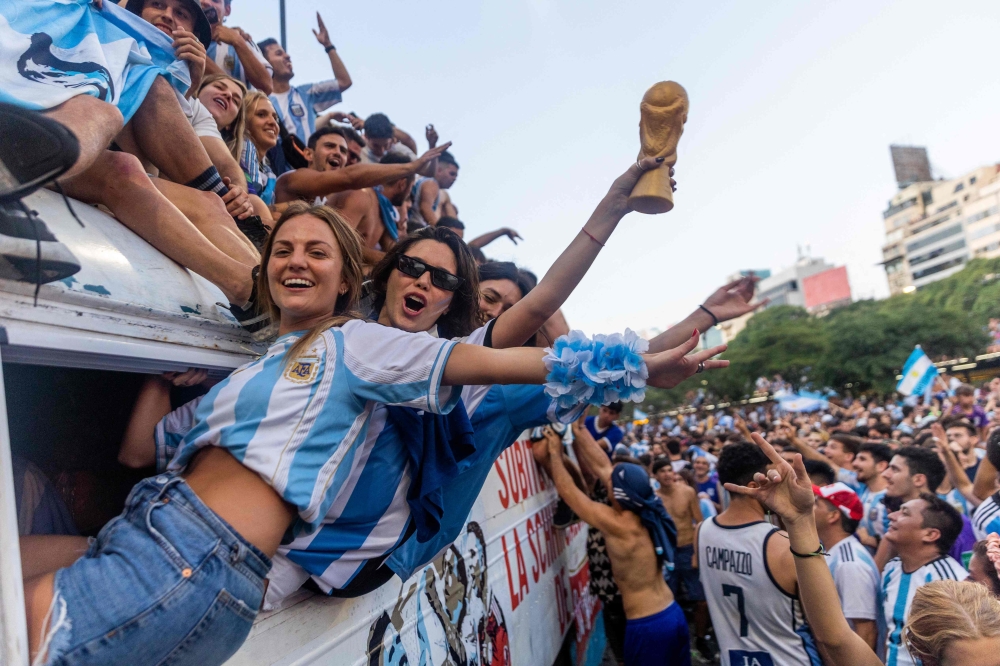 (FILES) In this file photo taken on December 18, 2022, fans of Argentina celebrate winning the Qatar 2022 World Cup against France at the Obelisk in Buenos Aires. More than 1.5 million Argentina fans applied for 63,000 tickets for the team's first appearance, in a friendly against Panama, since lifting the football World Cup in Qatar. 
Tickets for the match in Buenos Aires on March 23, 2023, sold out in two hours, according to the Deportick website, as local media said the virtual ticket line drew 1.5 million people.
 (Photo by TOMAS CUESTA / AFP)

