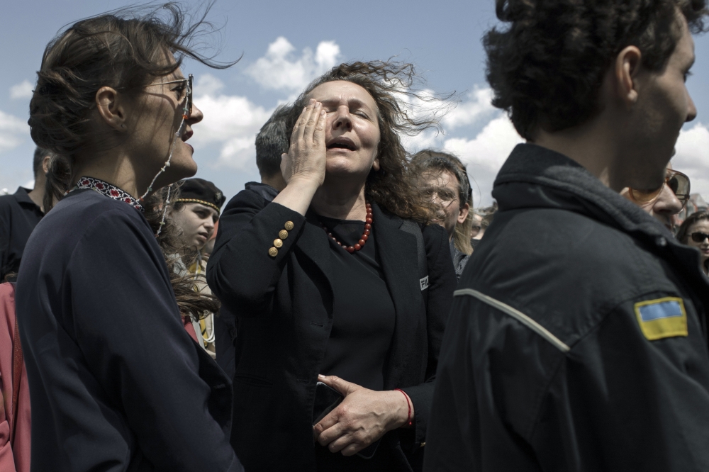 Mourners grieve during the funeral for fallen soldier Artemiy Dymyd at Lychakiv cemetery in Lviv, Ukraine.
