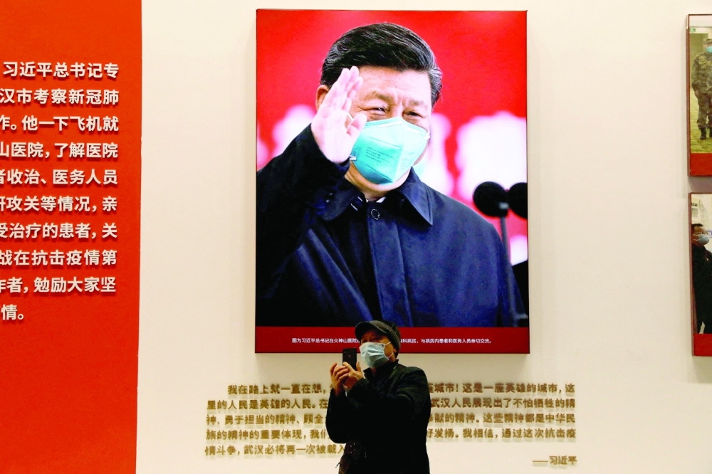 A visitor stands near an image of Chinese President Xi Jinping during an exhibition on the fight against the coronavirus disease (Covid-19). — Reuters
