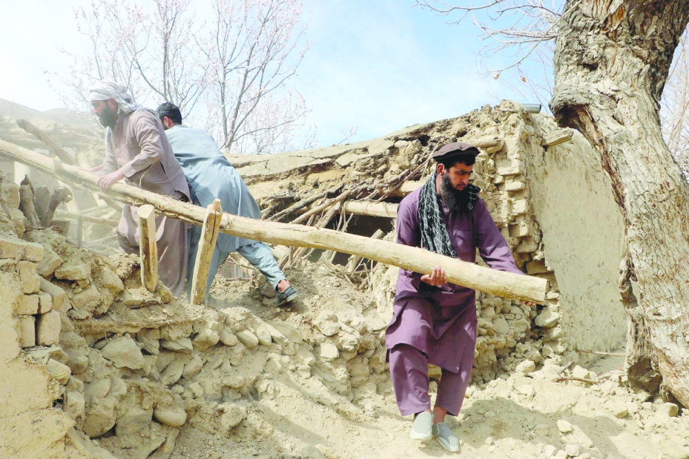 Residents clear debris from a damaged a house at Sooch village in Jurm district of Badakhshan Province in Afghanistan. — AFP 