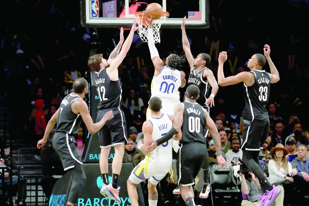 Dec 21, 2022; Brooklyn, New York, USA; Golden State Warriors forward Jonathan Kuminga (00) drives to the basket against Brooklyn Nets forward Joe Harris (12) and guard Edmond Sumner (4) and center Nic Claxton (33) and forward Kevin Durant (7) and forward Royce O'Neale (00) during the third quarter at Barclays Center. Mandatory Credit: Brad Penner-USA TODAY Sports