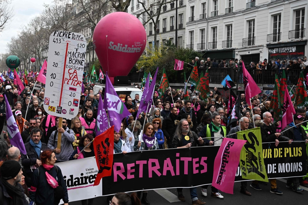 People take part in a demonstration, a week after the government pushed a pensions reform through parliament without a vote, Paris. —AFP 