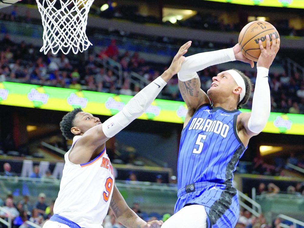 Orlando Magic forward Paolo Banchero (5) drives to the basket past New York Knicks guard RJ Barrett (9) in the third quarter at Amway Center. -- USA TODAY Sports