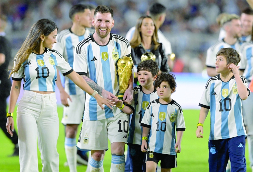 Argentina's forward Lionel Messi celebrates with his wife Antonela Roccuzzo (L) and their children Thiago (R), Mateo (C) and Ciro (2-R), during a recognition ceremony for the World Cup winning players, following the friendly football match between Argentina and Panama at the Monumental stadium in Buenos Aires on March 23, 2023. (Photo by JUAN MABROMATA / AFP)