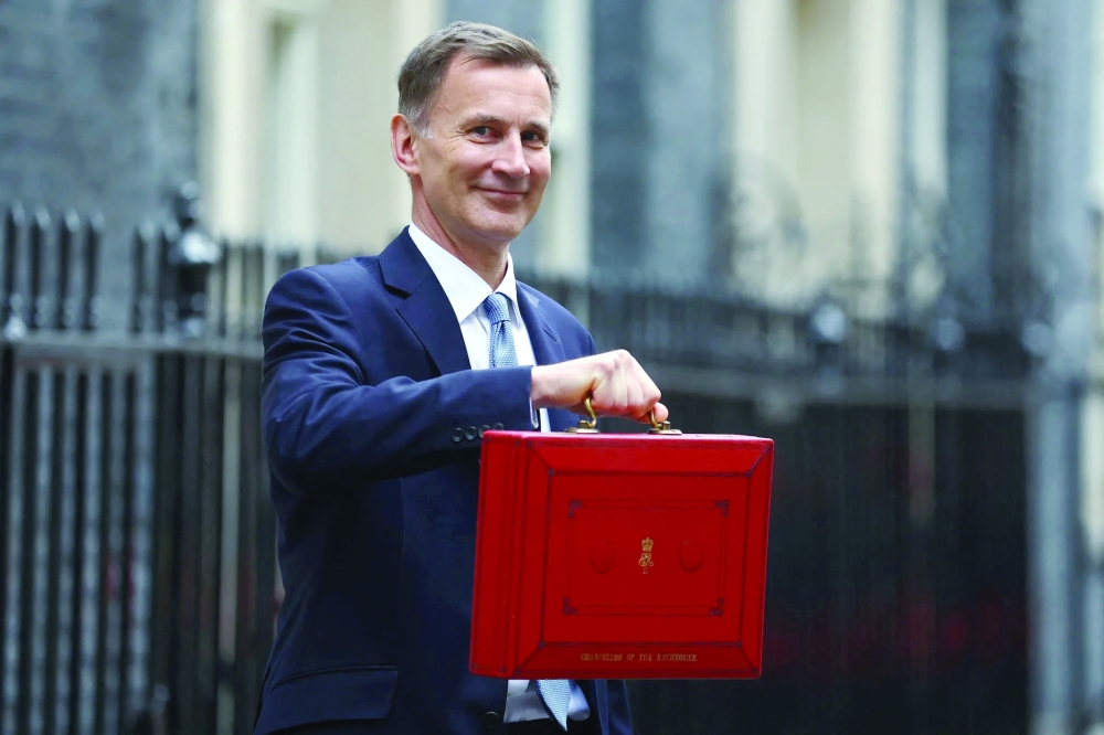 Chancellor of the Exchequer Jreremy Hunt holds a red box as he leaves 11 Downing Street to deliver his Spring Budget to UK Parliament. — Reuters