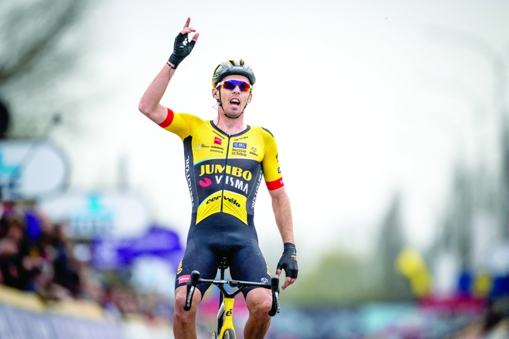 Jumbo-Visma's French rider Christophe Laporte celebrates as he cycles to the finish line to win the men elite race 'Dwars Door Vlaanderen' cycling race, 183,5 km from Roeselare to Waregem, on March 29, 2023. Belgium OUT
 (Photo by JASPER JACOBS / BELGA / AFP)

